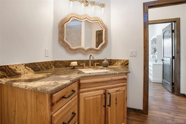 bathroom featuring hardwood / wood-style flooring and vanity with extensive cabinet space