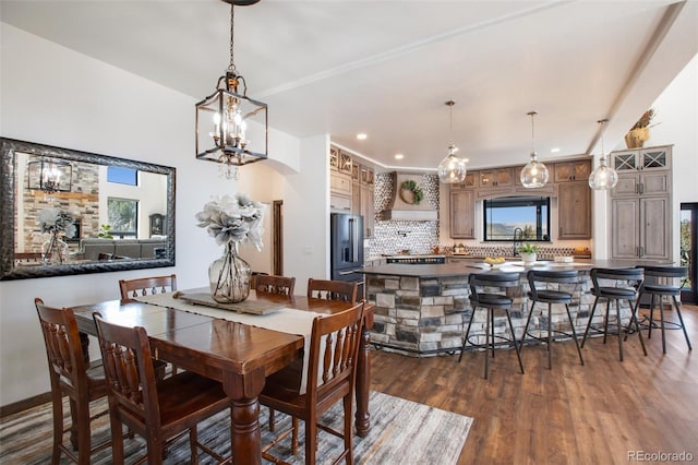 dining room featuring an inviting chandelier, a wealth of natural light, and dark hardwood / wood-style floors