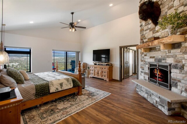 bedroom featuring access to exterior, a fireplace, high vaulted ceiling, and wood finished floors