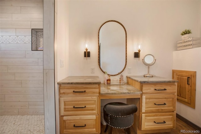 bathroom with a tile shower and vanity