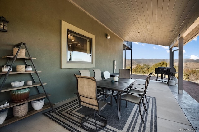 view of patio / terrace featuring grilling area, a mountain view, and outdoor dining area