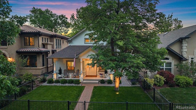 2340 S Columbine St, Denver, CO 80210 - view of front of home featuring stucco siding, covered porch, and a fenced front yard