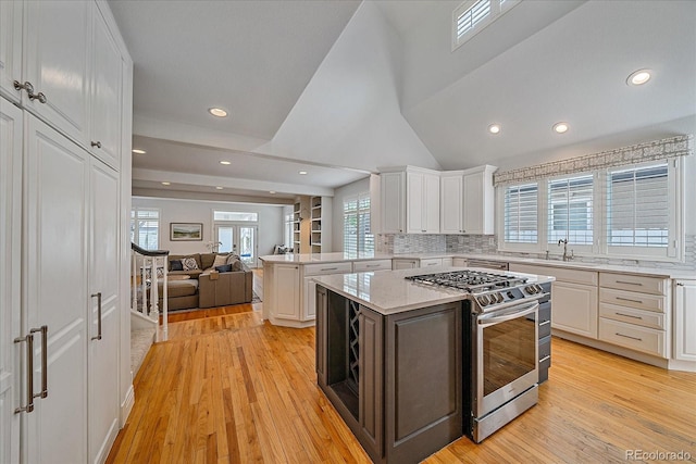 2340 S Columbine St, Denver, CO 80210 - kitchen with stainless steel range with gas cooktop, open floor plan, white cabinets, recessed lighting, and light wood-type flooring