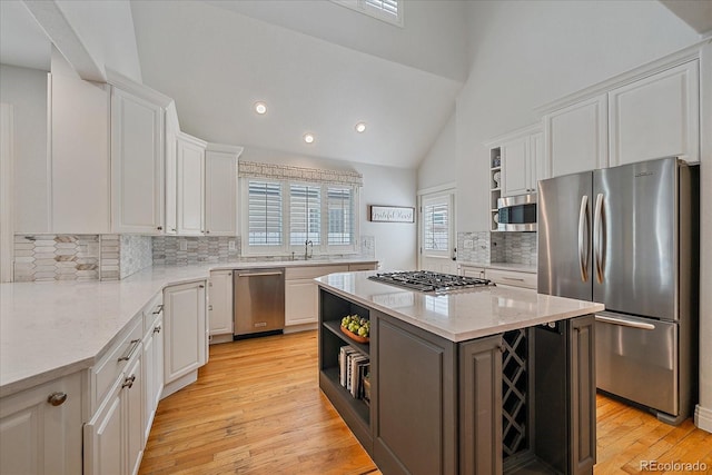 2340 S Columbine St, Denver, CO 80210 - kitchen featuring appliances with stainless steel finishes, white cabinets, open shelves, decorative backsplash, and a center island