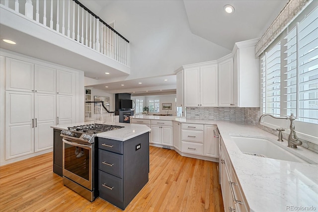 2340 S Columbine St, Denver, CO 80210 - kitchen with stainless steel range with gas stovetop, white cabinets, light stone countertops, decorative backsplash, and high vaulted ceiling