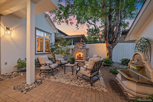 2340 S Columbine St, Denver, CO 80210 - patio terrace at dusk featuring a patio and an outdoor living space with a fireplace