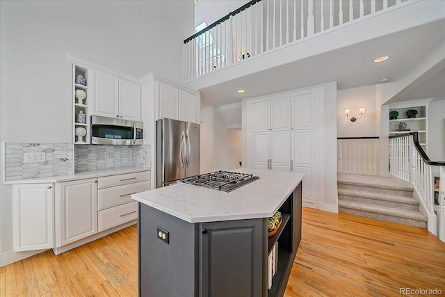 2340 S Columbine St, Denver, CO 80210 - kitchen featuring open shelves, appliances with stainless steel finishes, white cabinets, light wood finished floors, and a kitchen island