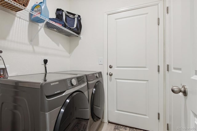 laundry room with separate washer and dryer and light wood-type flooring