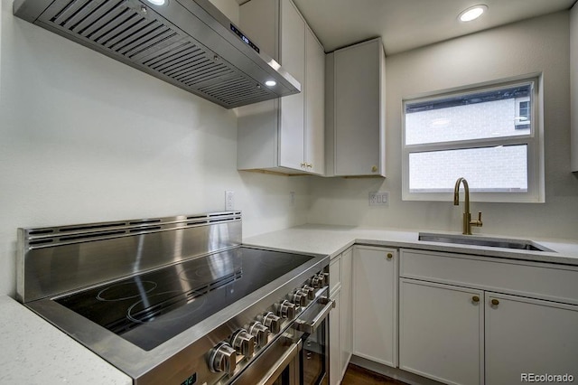 1815 S Monroe St, Denver, CO 80210 - kitchen with stainless steel electric range, wall chimney exhaust hood, light countertops, recessed lighting, and white cabinets