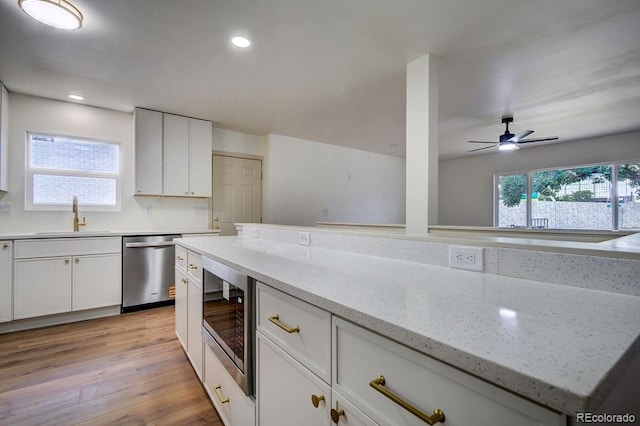 1815 S Monroe St, Denver, CO 80210 - kitchen featuring stainless steel appliances, white cabinetry, light wood-style floors, a ceiling fan, and recessed lighting