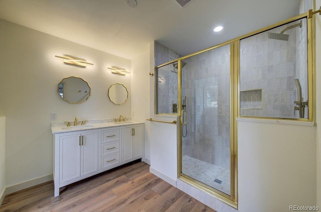 1815 S Monroe St, Denver, CO 80210 - bathroom with double vanity, a shower stall, wood finished floors, and recessed lighting