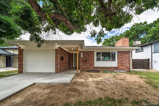 1815 S Monroe St, Denver, CO 80210 - ranch-style home with concrete driveway, a chimney, brick siding, and a garage