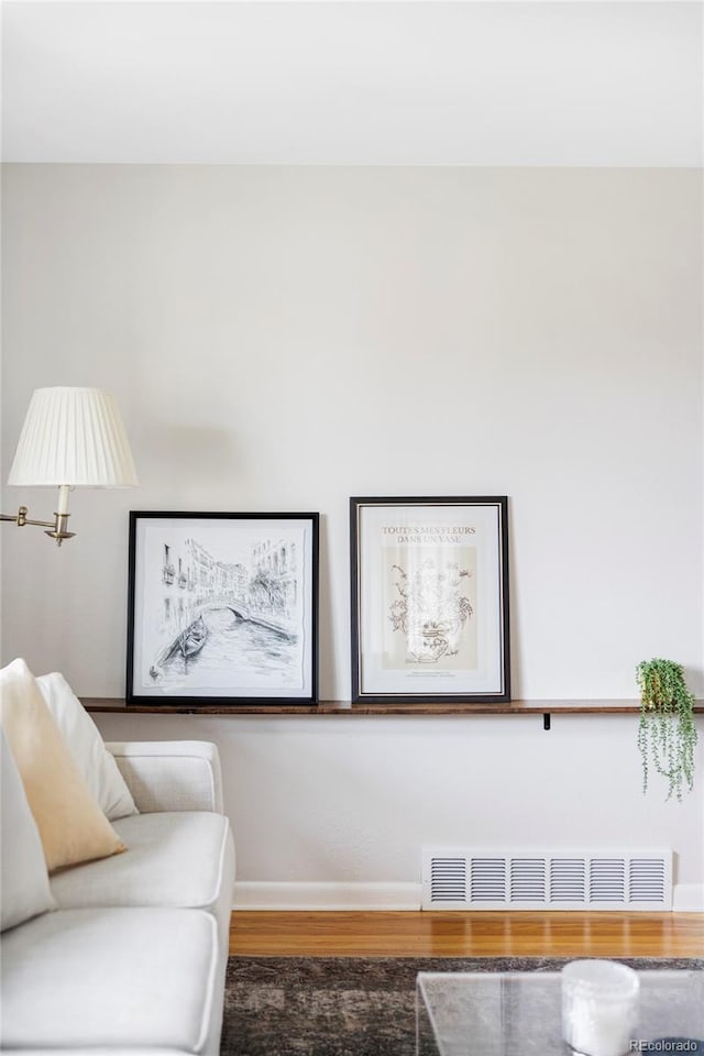 sitting room with baseboards, wood finished floors, and visible vents