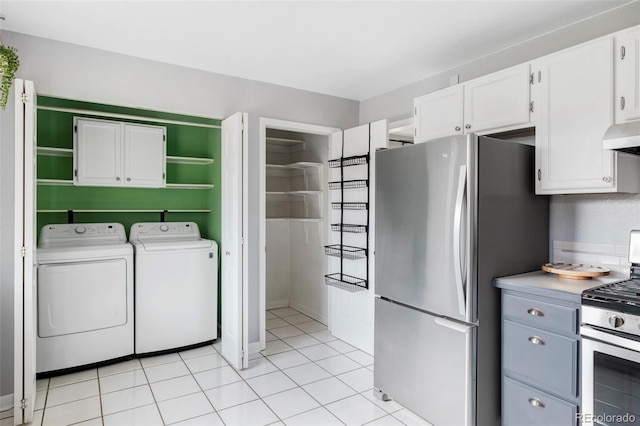 kitchen with washer and dryer, under cabinet range hood, stainless steel appliances, and white cabinets