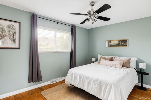 bedroom featuring visible vents, wood finished floors, baseboards, and ceiling fan