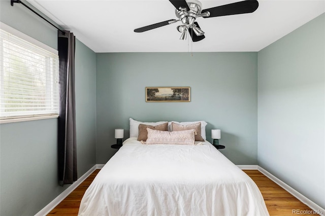 bedroom featuring wood finished floors, baseboards, and ceiling fan