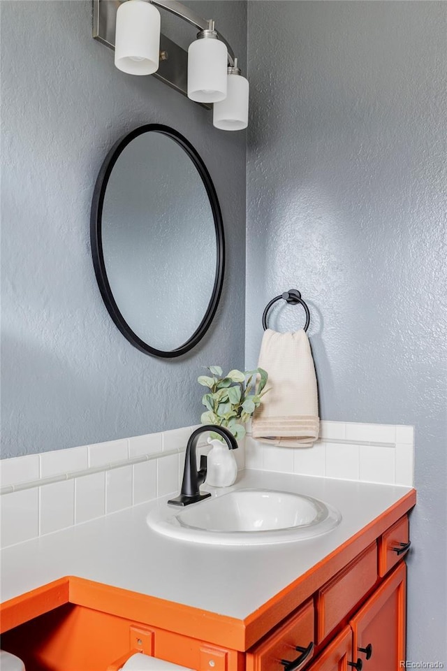 bathroom with a textured wall and vanity