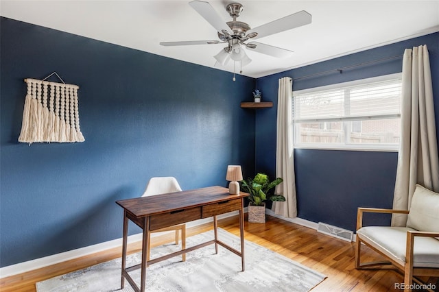 office featuring ceiling fan, baseboards, wood finished floors, and visible vents