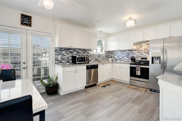 kitchen featuring white cabinetry, appliances with stainless steel finishes, decorative backsplash, and decorative light fixtures