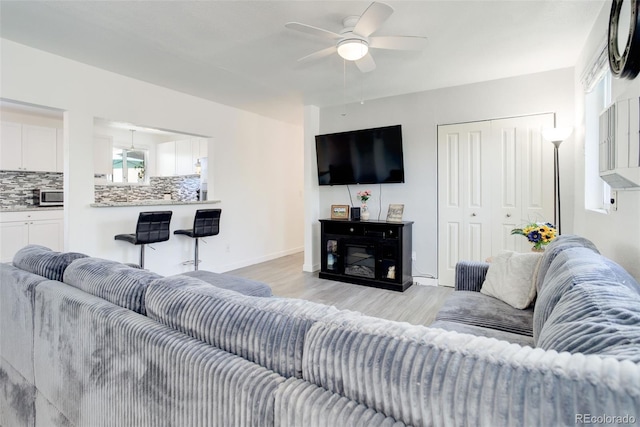 living room featuring ceiling fan and light hardwood / wood-style flooring