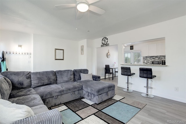 living room featuring ceiling fan and light hardwood / wood-style flooring