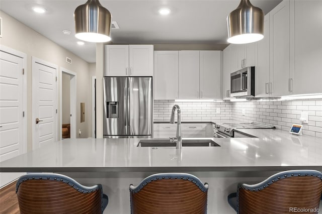 kitchen featuring a sink, white cabinetry, tasteful backsplash, and stainless steel appliances