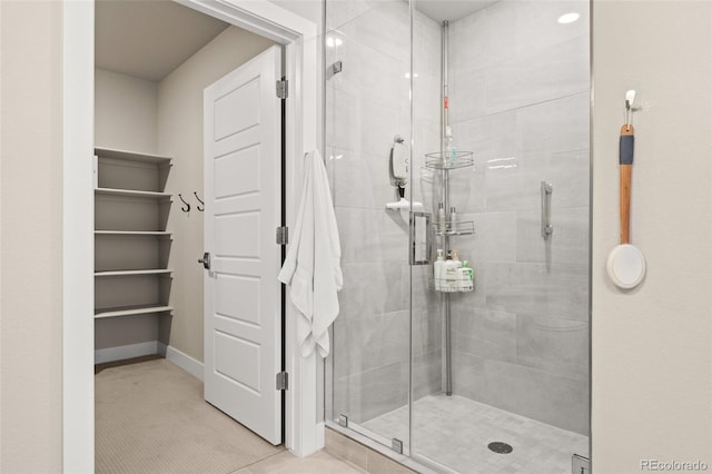 bathroom with baseboards and a shower stall