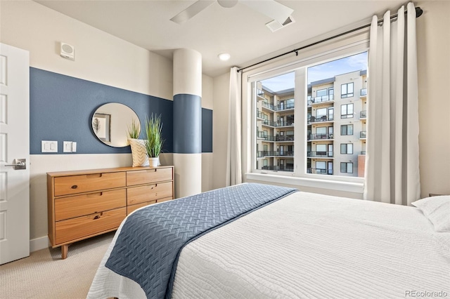 carpeted bedroom with visible vents, baseboards, and ceiling fan