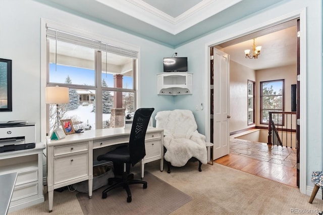 carpeted home office with an inviting chandelier, ornamental molding, and a raised ceiling