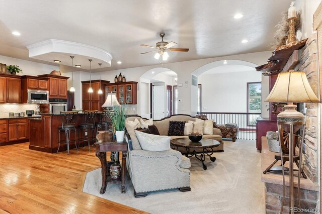 living room with light hardwood / wood-style floors and ceiling fan