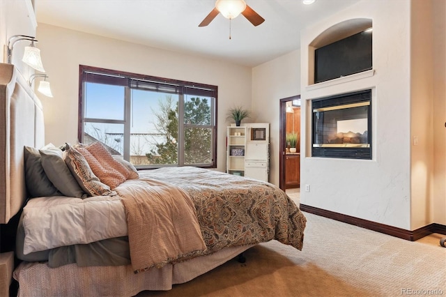 bedroom featuring carpet floors, ceiling fan, and a multi sided fireplace