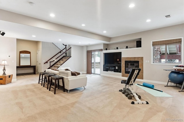 living room with a tiled fireplace and light colored carpet