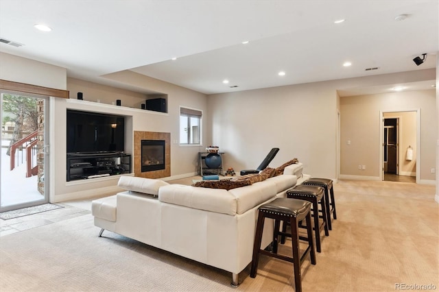 living room with a tile fireplace and light colored carpet