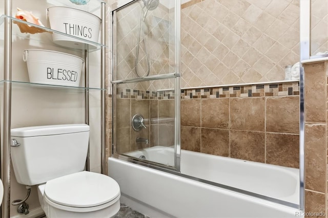 bathroom featuring bath / shower combo with glass door and toilet