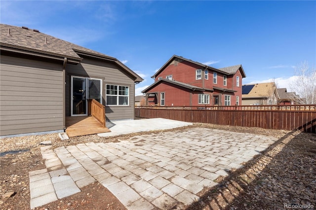 rear view of house with a patio area and fence