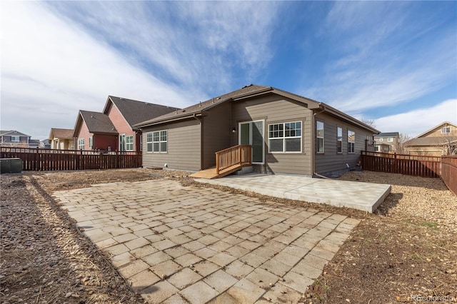 rear view of property featuring a patio and fence