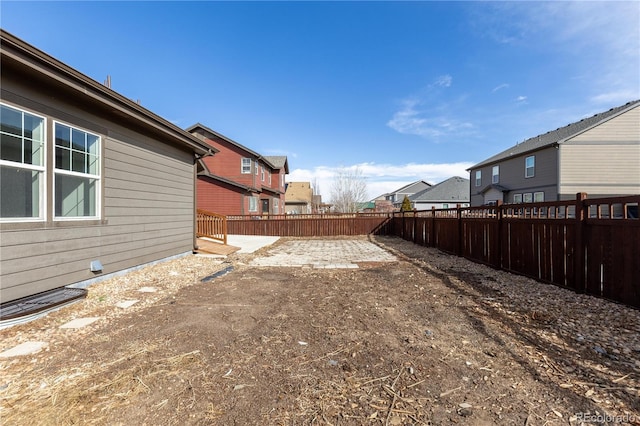 view of yard featuring a residential view, a fenced backyard, and a patio