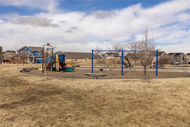 community play area featuring a lawn and a residential view