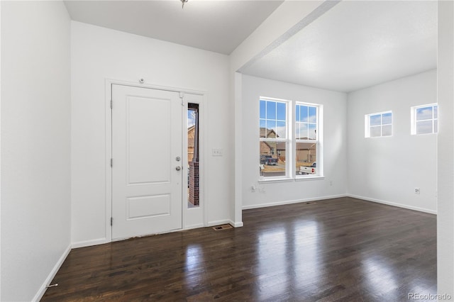 foyer entrance with baseboards, visible vents, and wood finished floors