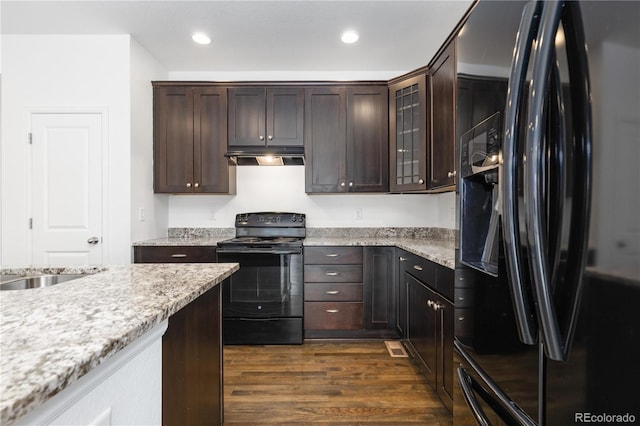 kitchen featuring dark wood-type flooring, recessed lighting, dark brown cabinetry, and black appliances