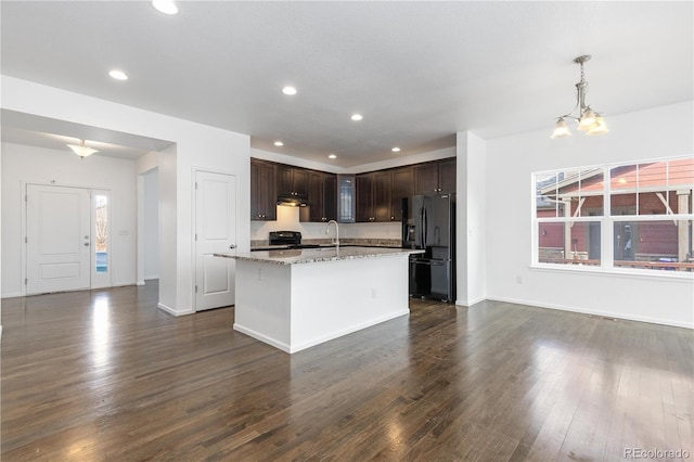 kitchen featuring black appliances, dark wood finished floors, and a wealth of natural light