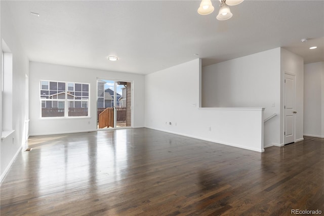 unfurnished living room with wood finished floors and baseboards