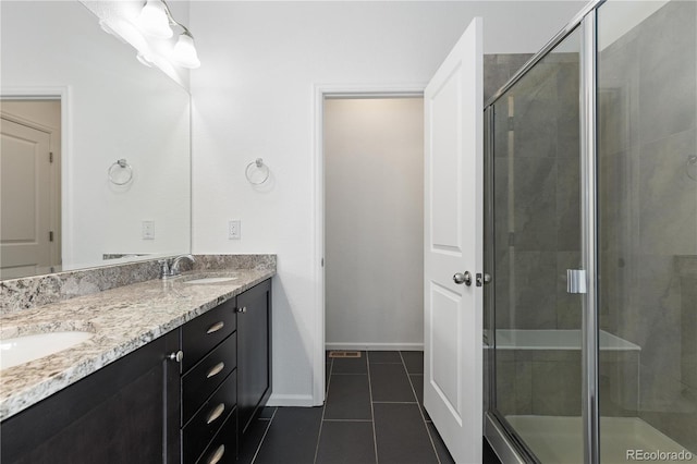 bathroom with a stall shower, tile patterned flooring, a sink, and double vanity