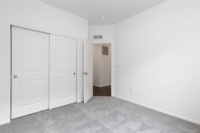 unfurnished bedroom featuring carpet, a closet, visible vents, and baseboards