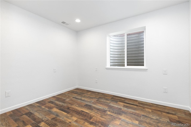 unfurnished room with recessed lighting, dark wood finished floors, visible vents, and baseboards