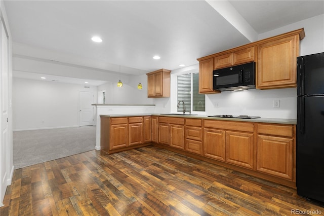 kitchen with light countertops, a sink, a peninsula, and black appliances