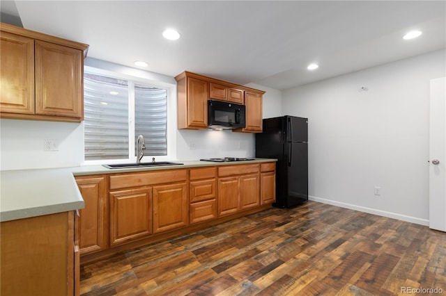 kitchen with black appliances, dark wood-type flooring, a sink, and recessed lighting