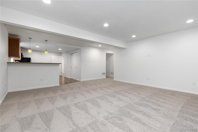 unfurnished living room with carpet, baseboards, and recessed lighting