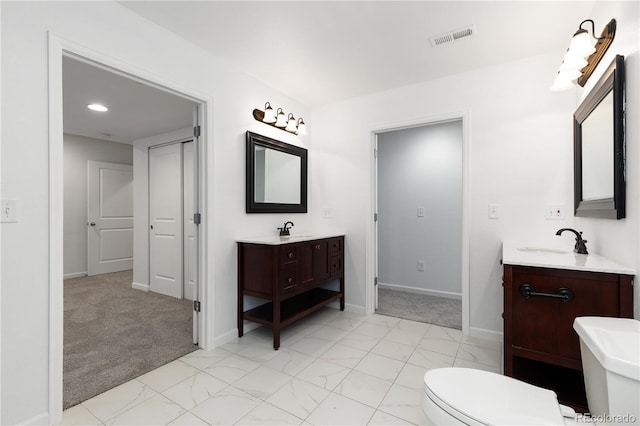 full bath featuring marble finish floor, two vanities, a sink, and visible vents