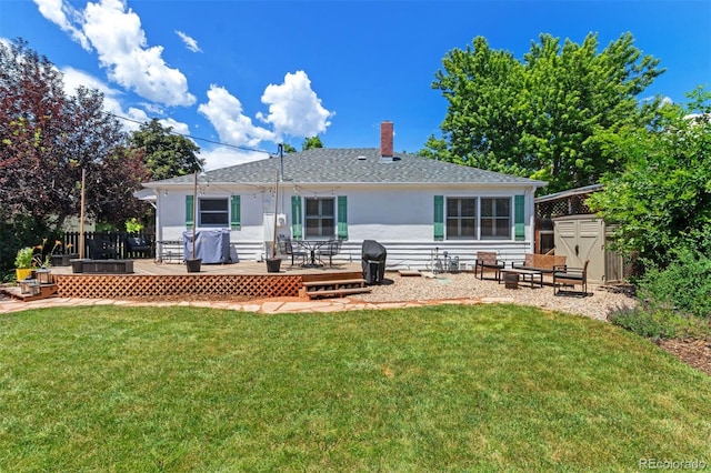 2309 Magellan St, Colorado Springs, CO 80907 - back of property featuring a wooden deck, a chimney, a lawn, a shingled roof, and a shed
